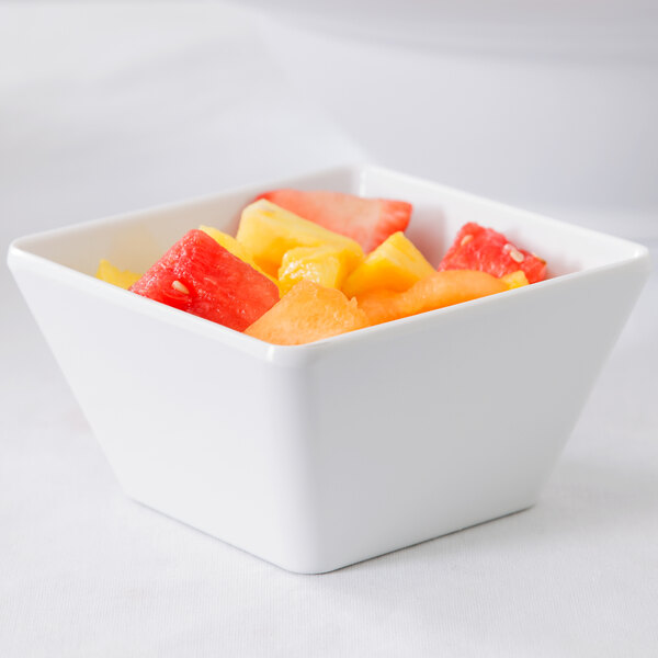 An American Metalcraft white square melamine bowl filled with fruit.