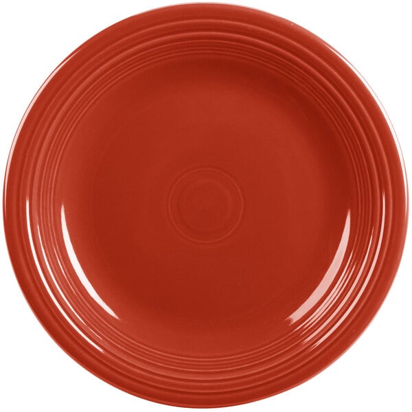 A close-up of a Scarlet red Fiesta® dinner plate with a rim.