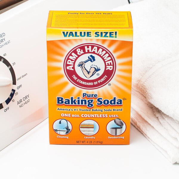 A yellow and orange Arm & Hammer box of baking soda on a kitchen counter.