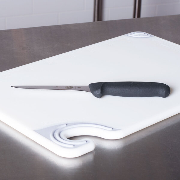 A Victorinox narrow stiff boning knife with a black handle on a cutting board.