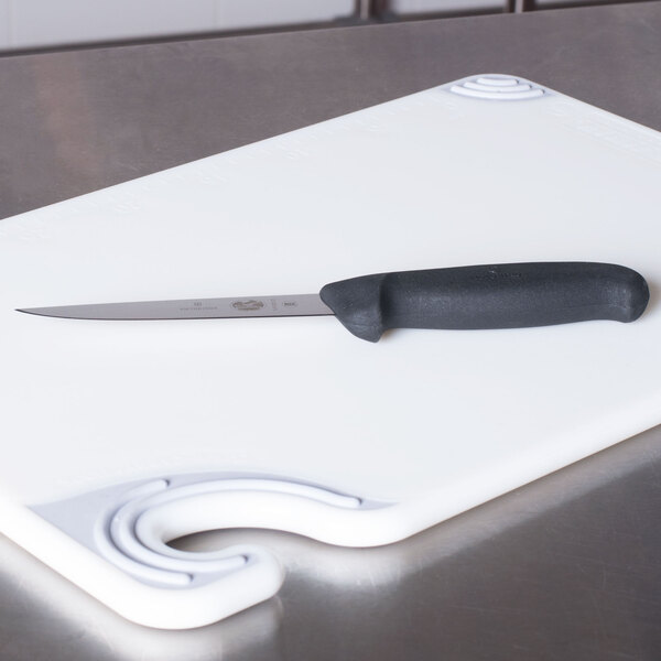 A Victorinox wide stiff boning knife on a cutting board.
