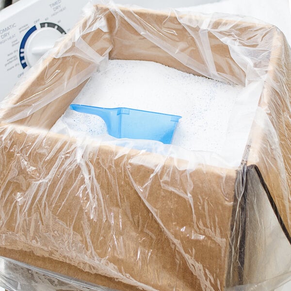 A box of OxiClean Versatile Stain Remover with a plastic bag and a blue container with white powder inside.