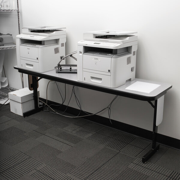 A Correll seminar table with two printers on it.