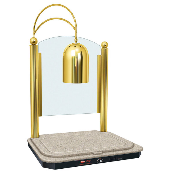 A Hatco decorative carving station with a Bermuda sand-colored heated base and bright brass finish with a golden lamp.