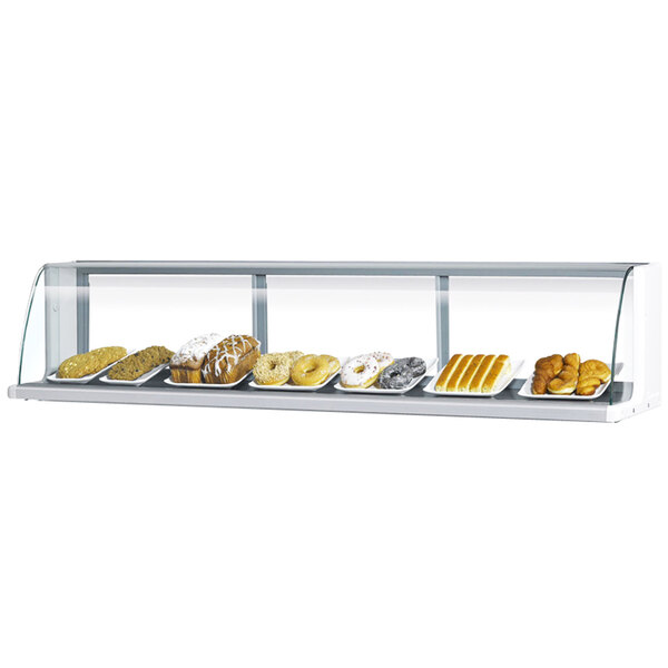 A Turbo Air white glass display case filled with pastries on a bakery counter.
