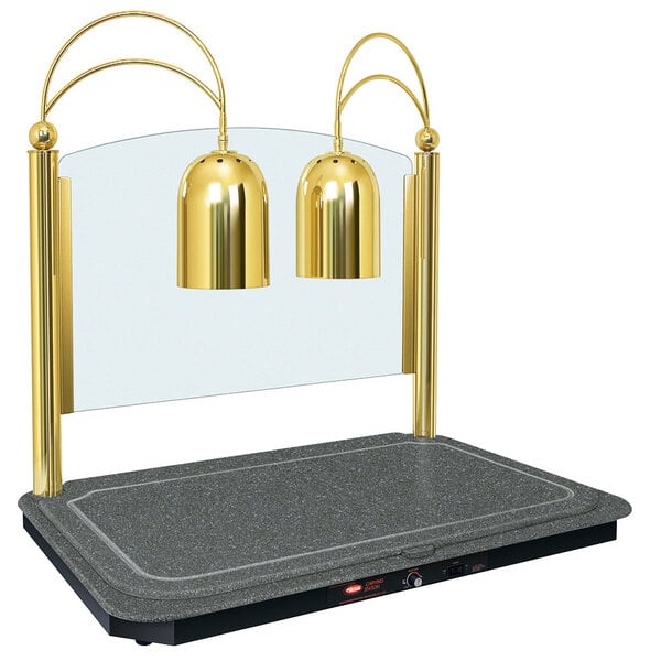 A Hatco brass carving station with two gold lamps over a counter.