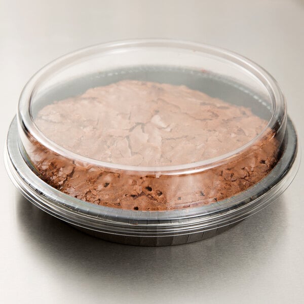A chocolate cake in a Solut round paperboard container with a clear lid.