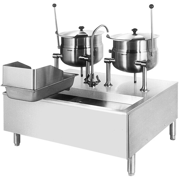A Cleveland stainless steel modular stand with 2 tilting steam kettles on a counter.
