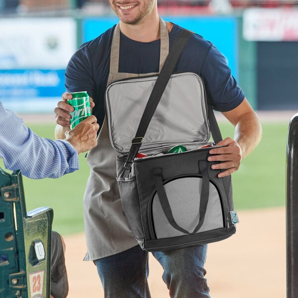 A man opening a Choice black insulated cooler bag with a beverage inside.