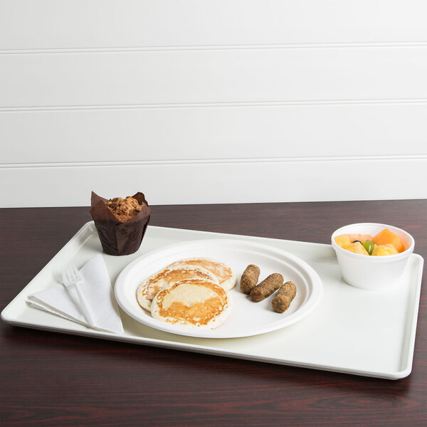 A white Cambro dietary tray with a plate of pancakes, sausages, a muffin, and a bowl of fruit.