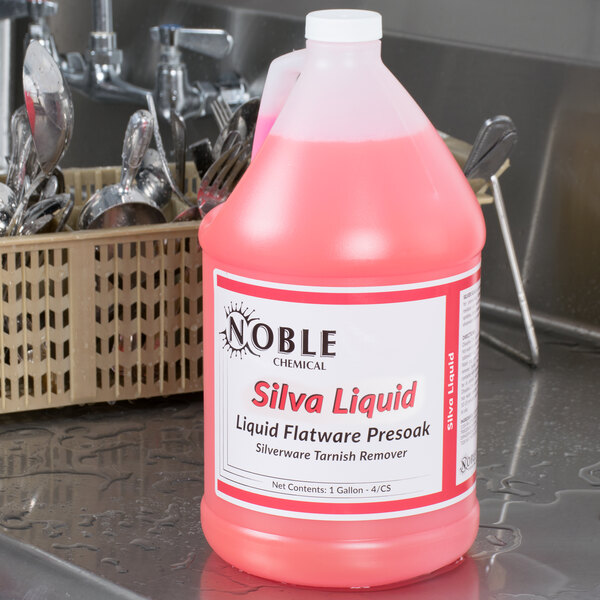 A pink bottle of Noble Chemical Silva-Liquid on a counter in a professional kitchen.