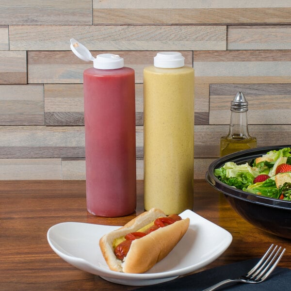 A hot dog on a plate with ketchup and mustard in a Tablecraft squeeze bottle.