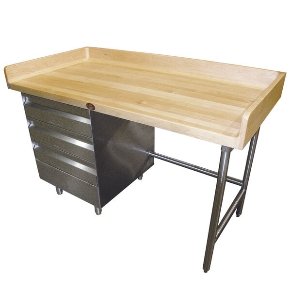 An Advance Tabco wood top baker's table with stainless steel base and drawers.