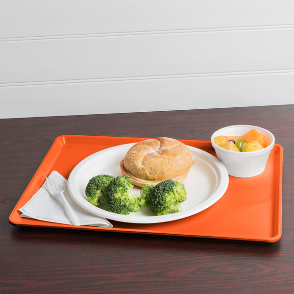 A Cambro orange pizazz dietary tray holding a plate of food with broccoli and a drink.