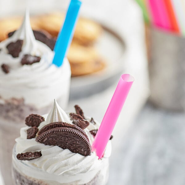 A close up of a milkshake with cookies and a Choice Colossal neon straw.