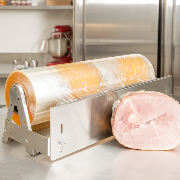 A roll of Berry heavy-duty plastic wrap next to a large roll of ham.