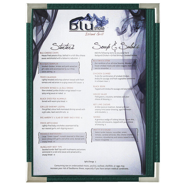 A Menu Solutions green menu board with silver corners on a table in a fine dining restaurant.