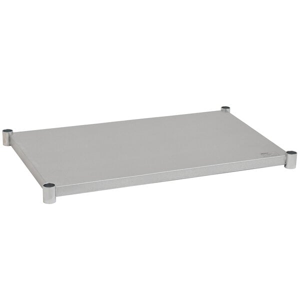 A white rectangular metal shelf with black handles attached to metal legs under a table.