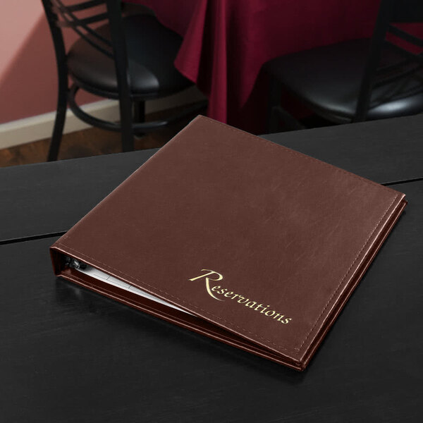 A brown leather restaurant menu cover on a black table.