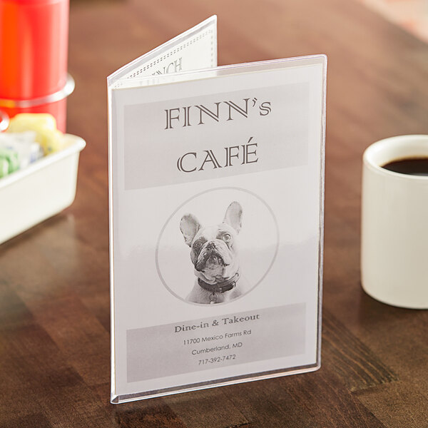A clear menu cover with a menu inside on a table in a brunch café.