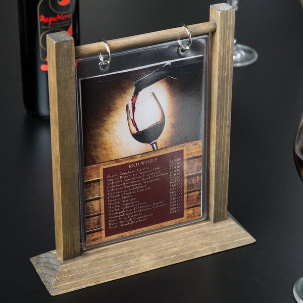 A Menu Solutions wood table tent on a table with a wine glass.