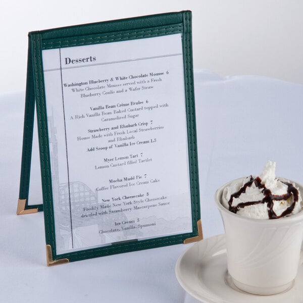 A green Menu Solutions table tent on a table with a cup of coffee.