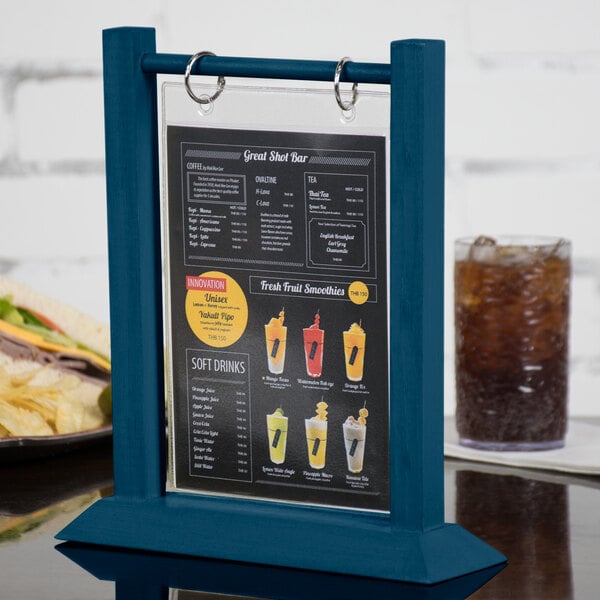 A Menu Solutions denim wood flip top table tent on a table with a sandwich and a drink.