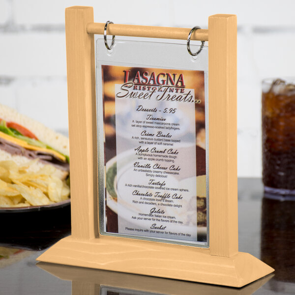 A Menu Solutions natural wood flip top table tent on a table.