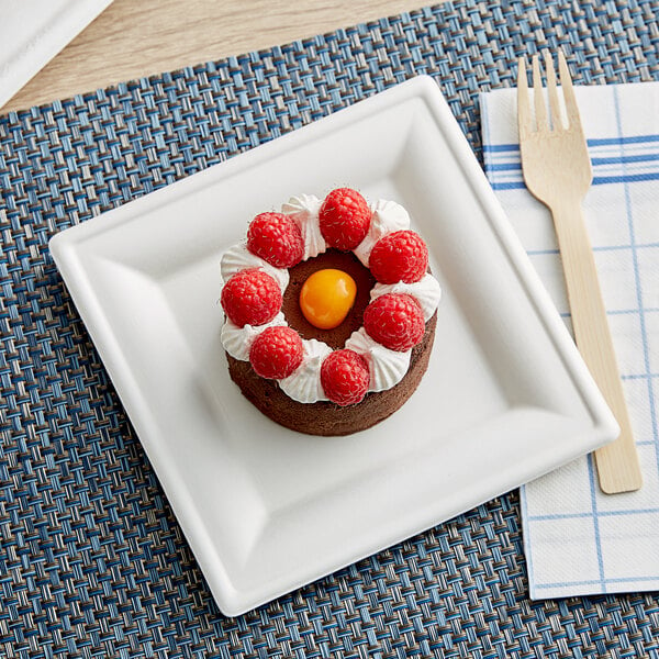 A small chocolate cake with raspberries and cream on a white EcoChoice compostable sugarcane square plate.
