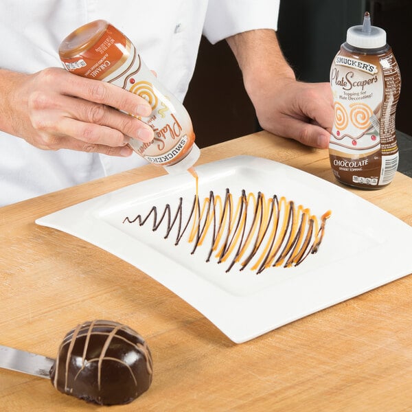 A person using Smucker's Chocolate Platescapers to pour chocolate on a dessert.