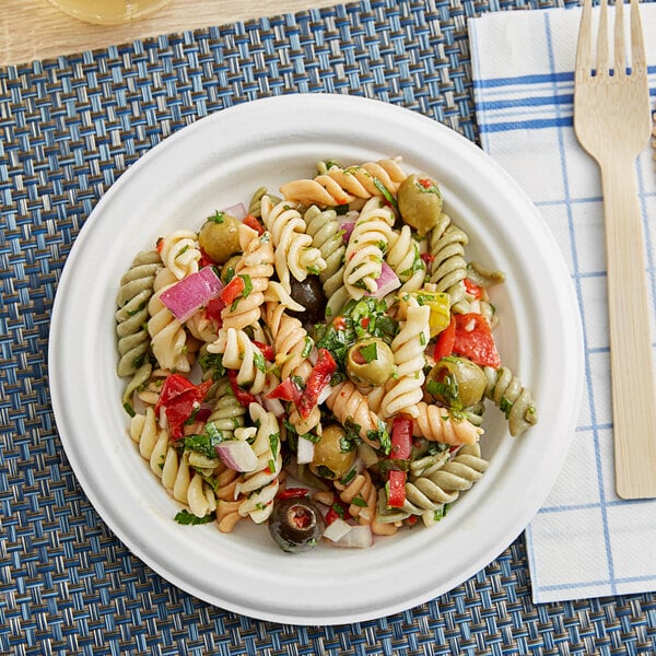 A plate of pasta salad on a table with an EcoChoice Compostable Sugarcane plate.