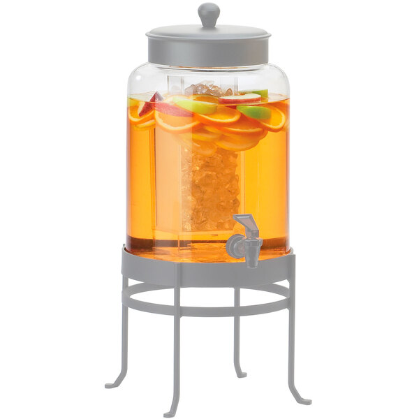 A Cal-Mil glass beverage container with orange juice and fruit in it.