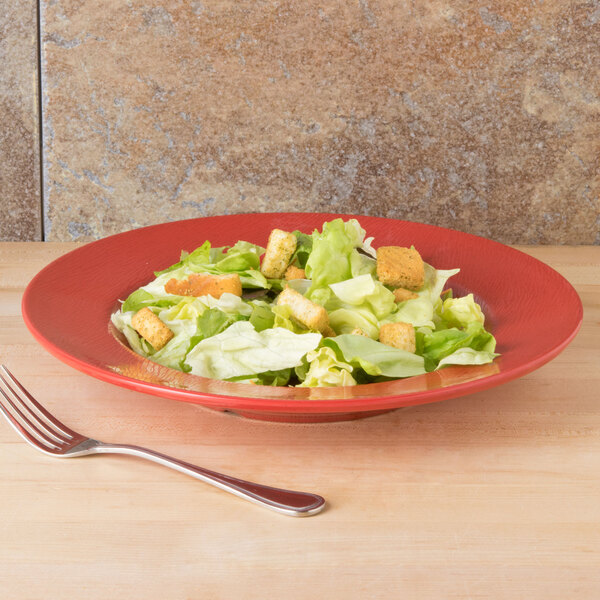A red GET Etchedware melamine bowl with salad on a table.