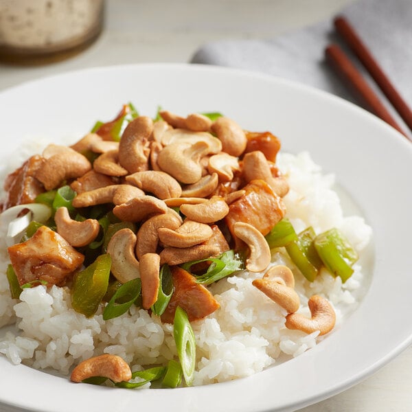 A plate of rice with cashews and cashew pieces.