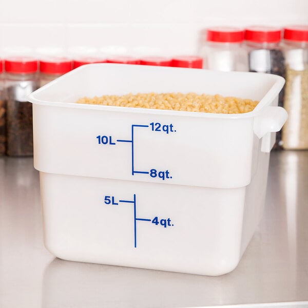 A close up of a white Cambro CamSquares polyethylene food storage container with measurements on it.
