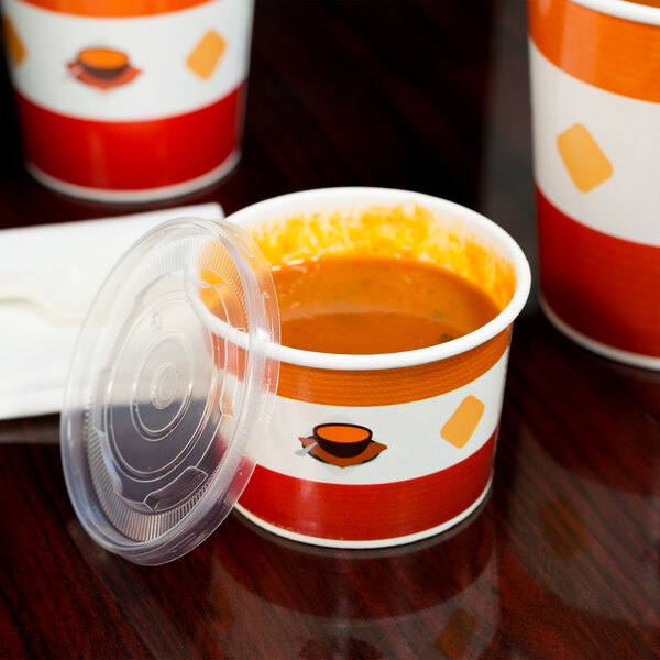 A Choice paper soup cup filled with soup and covered with a plastic lid.