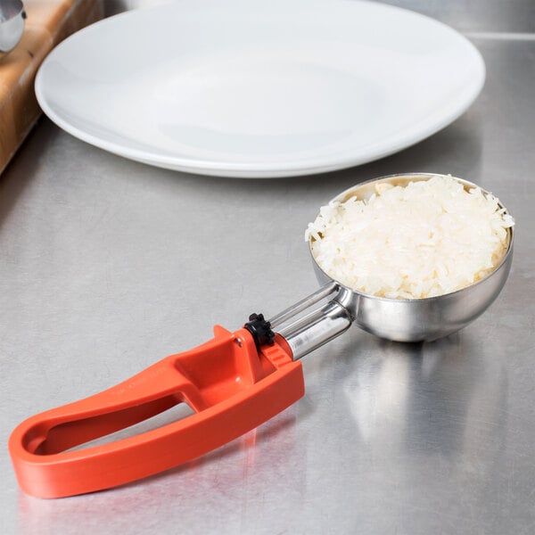 The Vollrath Jacob's Pride Orange Squeeze Handle Disher #4 on a white background.