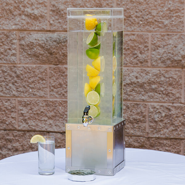 A Cal-Mil stainless steel infusion beverage dispenser with lemons and limes in it.