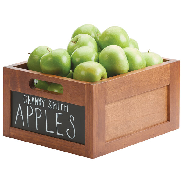 A Cal-Mil bamboo-colored wood ice housing with a chalkboard front filled with green apples.