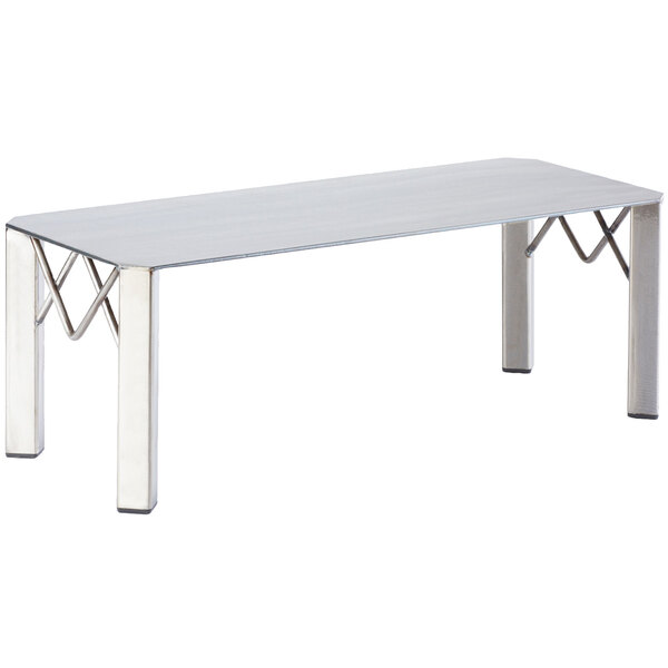 A white rectangular Cal-Mil display riser with metal legs on a table.