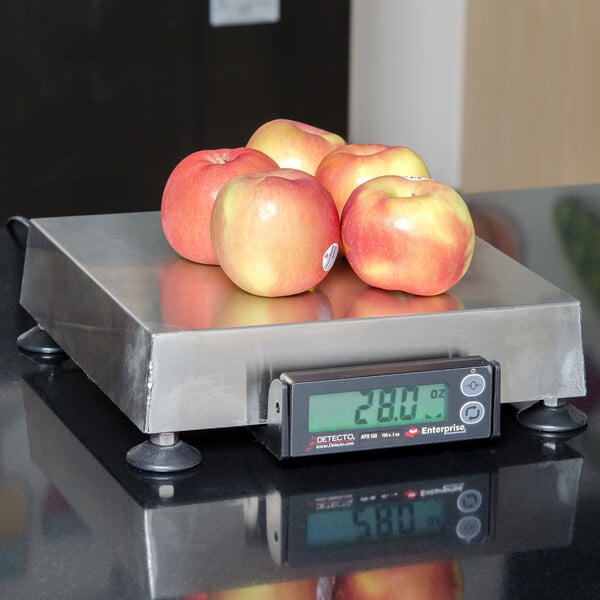A Cardinal Detecto legal for trade scale on a counter with apples on it.