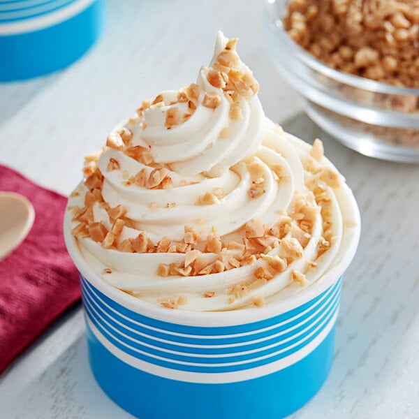 A bowl of ice cream with whipped cream and toffee bits.