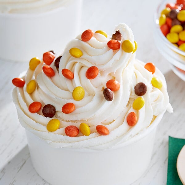 A cup of ice cream with REESE'S Mini Pieces on top.