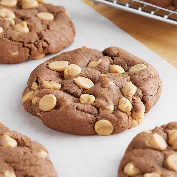 A close up of a REESE'S peanut butter chocolate chip cookie with nuts on top.