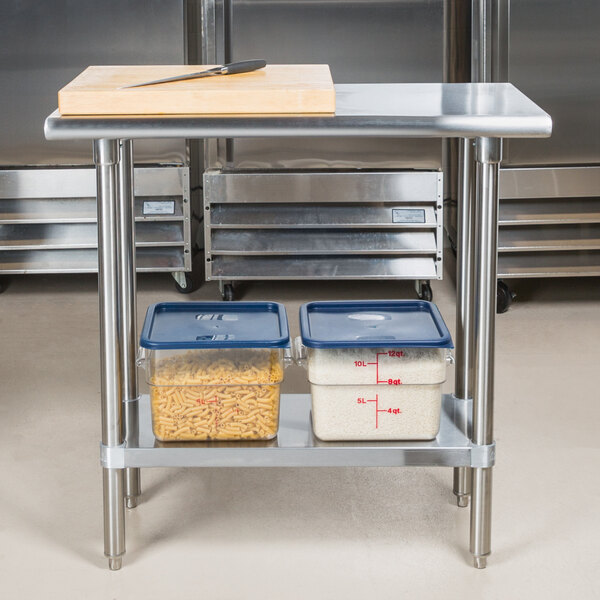 An Advance Tabco stainless steel work table with a stainless steel undershelf holding containers of food.