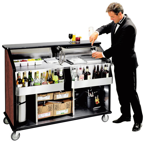 A man in a tuxedo pours a drink at a Lakeside portable bar.