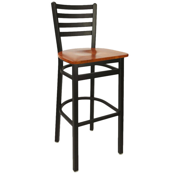 A BFM Seating black metal ladder back barstool with a cherry wooden seat.