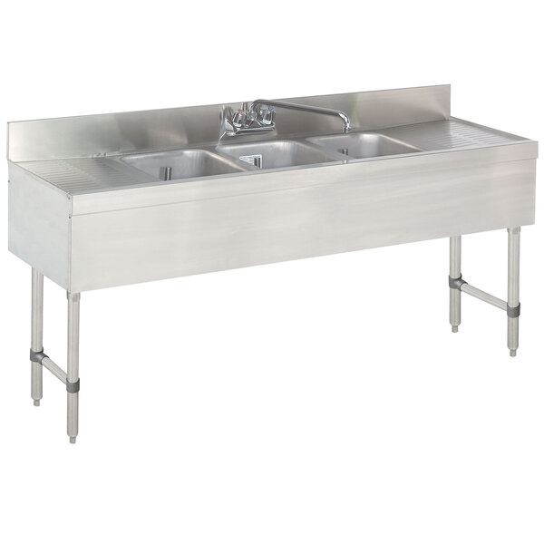 A stainless steel Advance Tabco underbar sink with three compartments and two drainboards.