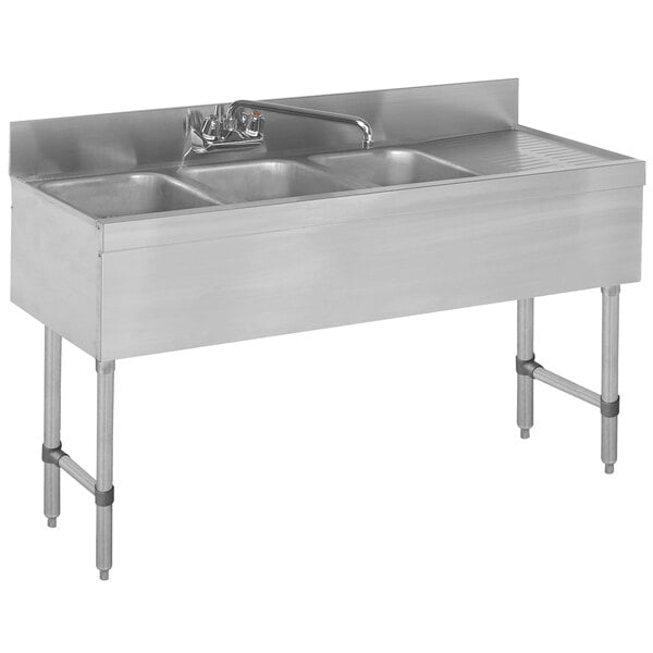 A stainless steel Advance Tabco underbar sink with three compartments and a drainboard.