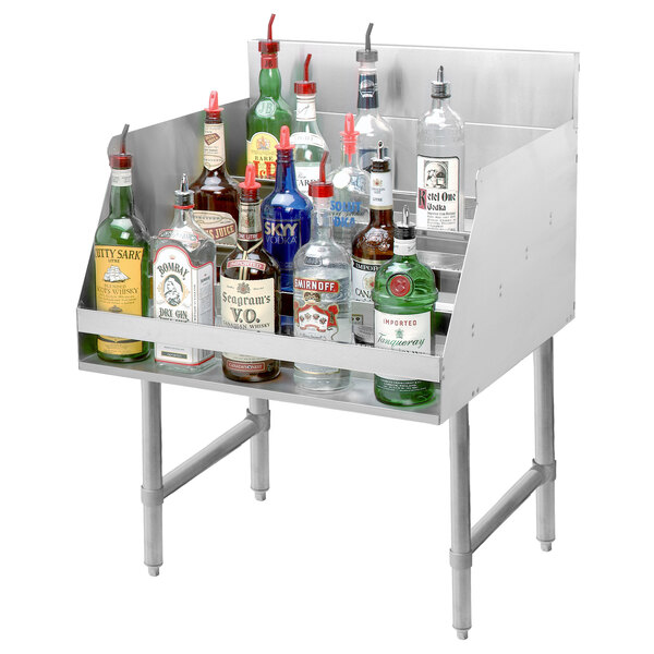 An Advance Tabco stainless steel liquor display rack on a counter with bottles on it.